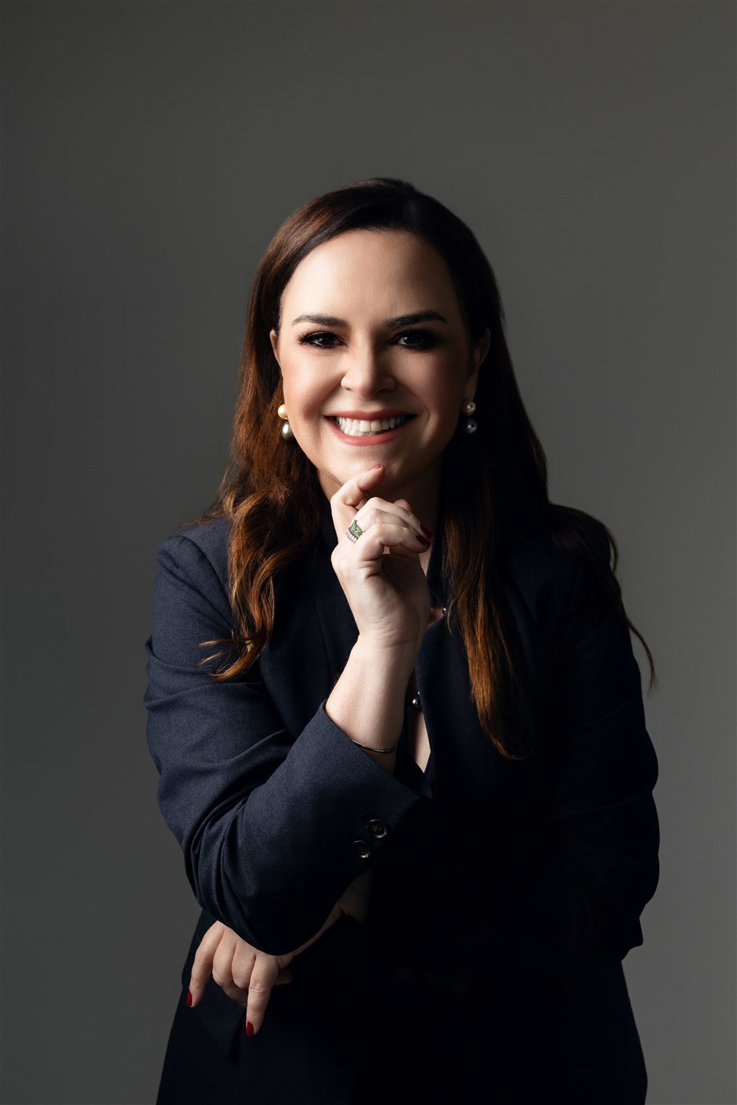 Carol Cunha Melo sorrindo, de blazer escuro