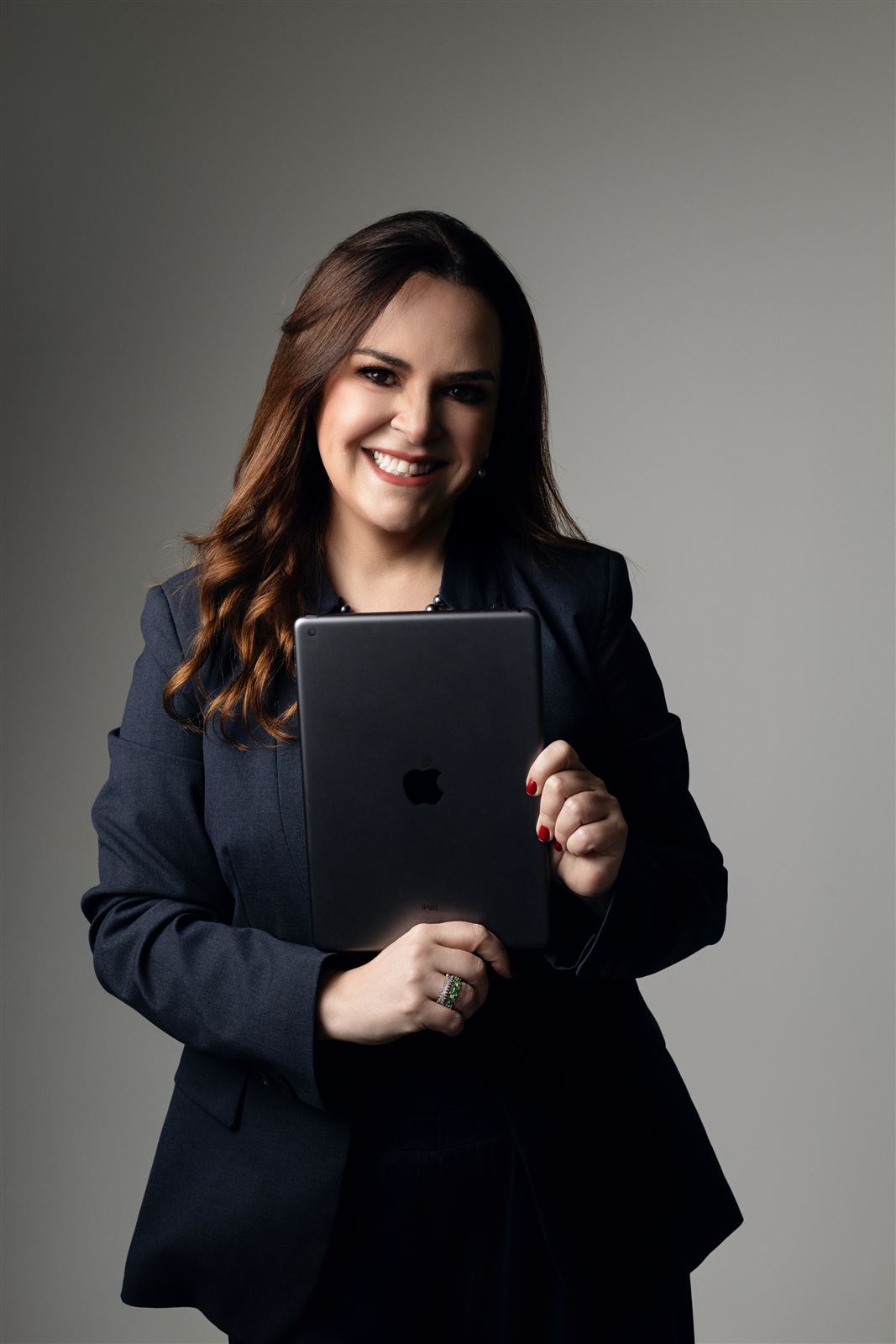 Carol Cunha Melo segurando um tablet, pronta para o atendimento online